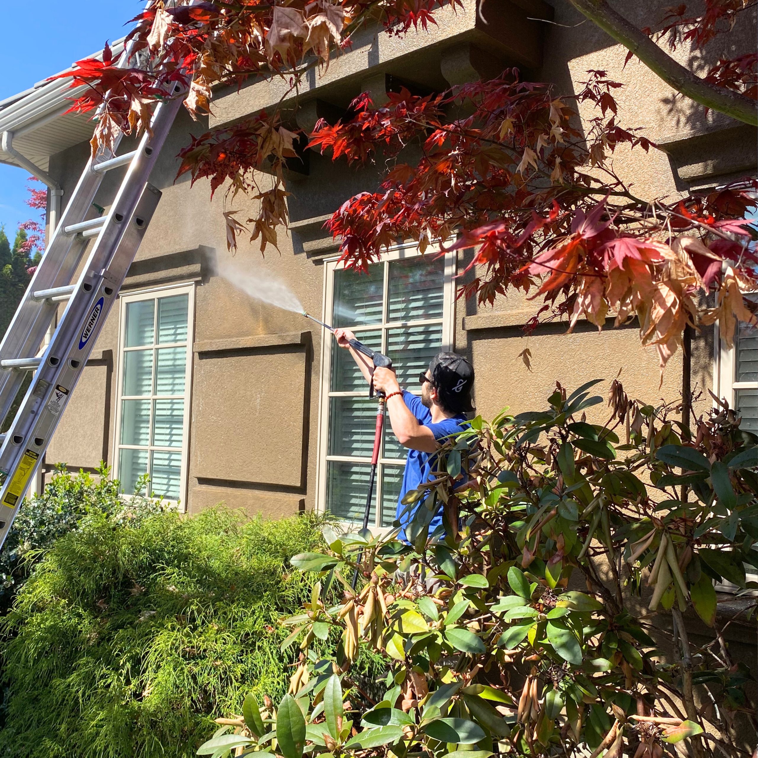 professional washer soft washing an exterior home in kelowna bc